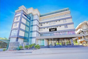 A multi-story building with a sign reading 'TOWNHOUSE OAK Company Serviced'. - Super Townhouse Oak Electronic City (Anekal)