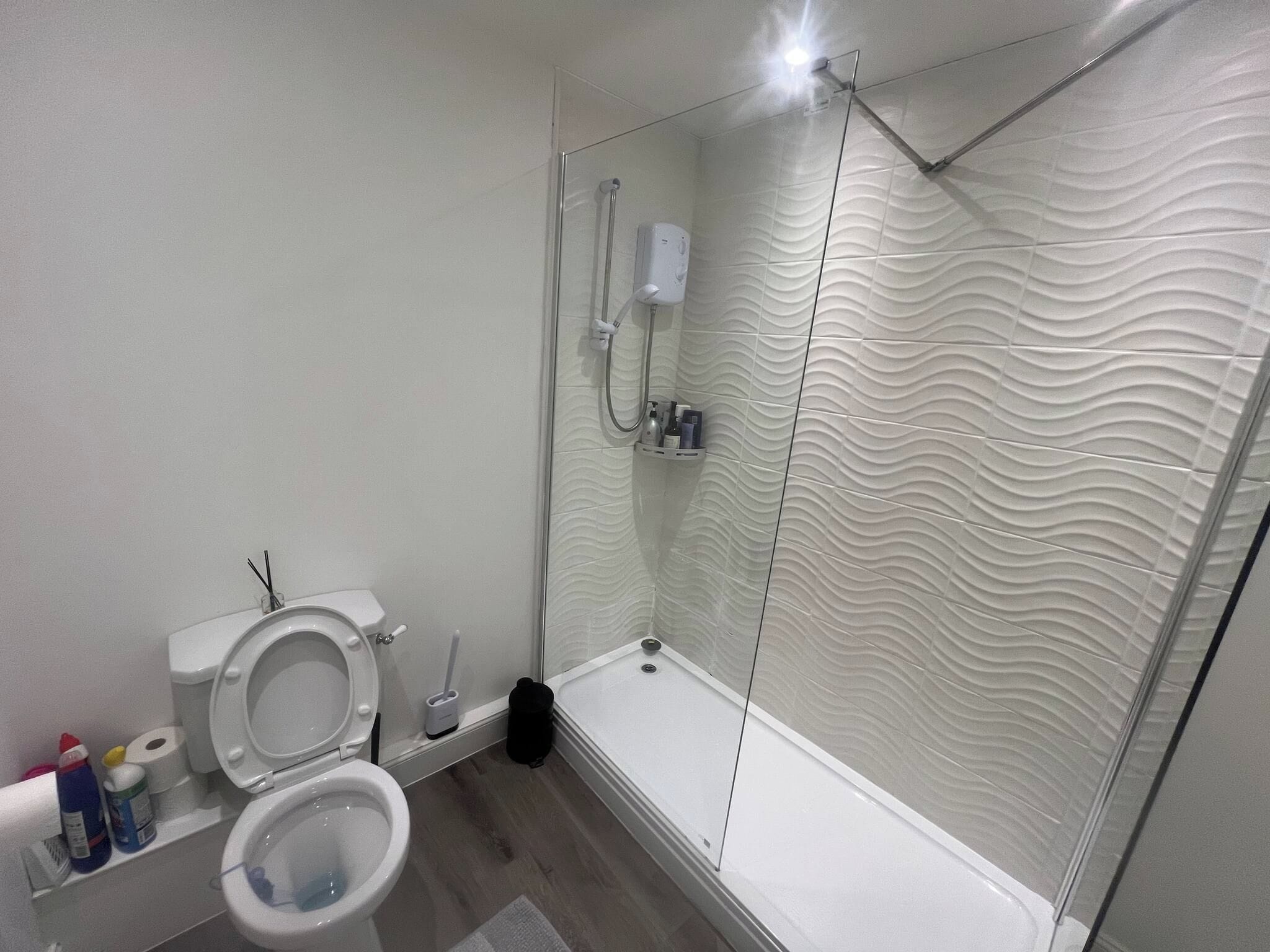 A modern bathroom with a shower, toilet, and bidet.