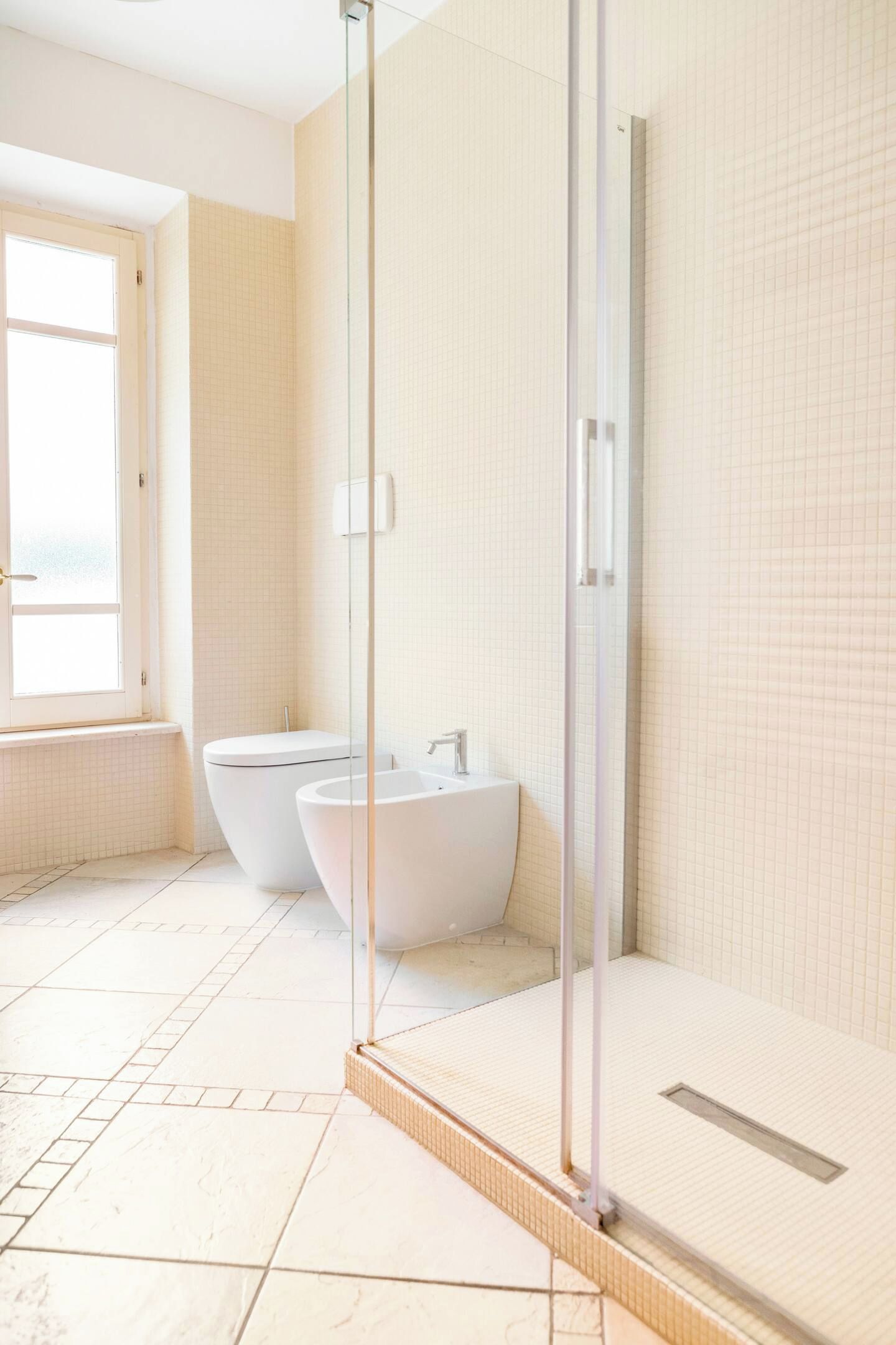 Een moderne badkamer met een douchecabine van glas, een badkuip en een wastafel.