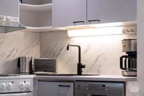 A modern kitchen with a built-in stove, a toaster, a coffee maker, and a dishwasher. - Leviraitti 5 911 by Holiday in Lapland (Levi)