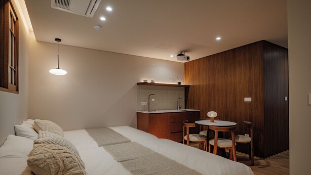 Ein modernes Schlafzimmer mit einem großen Bett, einem kleinen Schreibtisch und einem Stuhl.