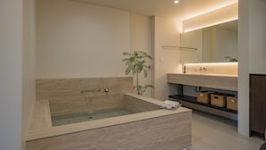 Ein modernes Badezimmer mit freistehender Badewanne, einem großen Spiegel und einem minimalistischen Design.