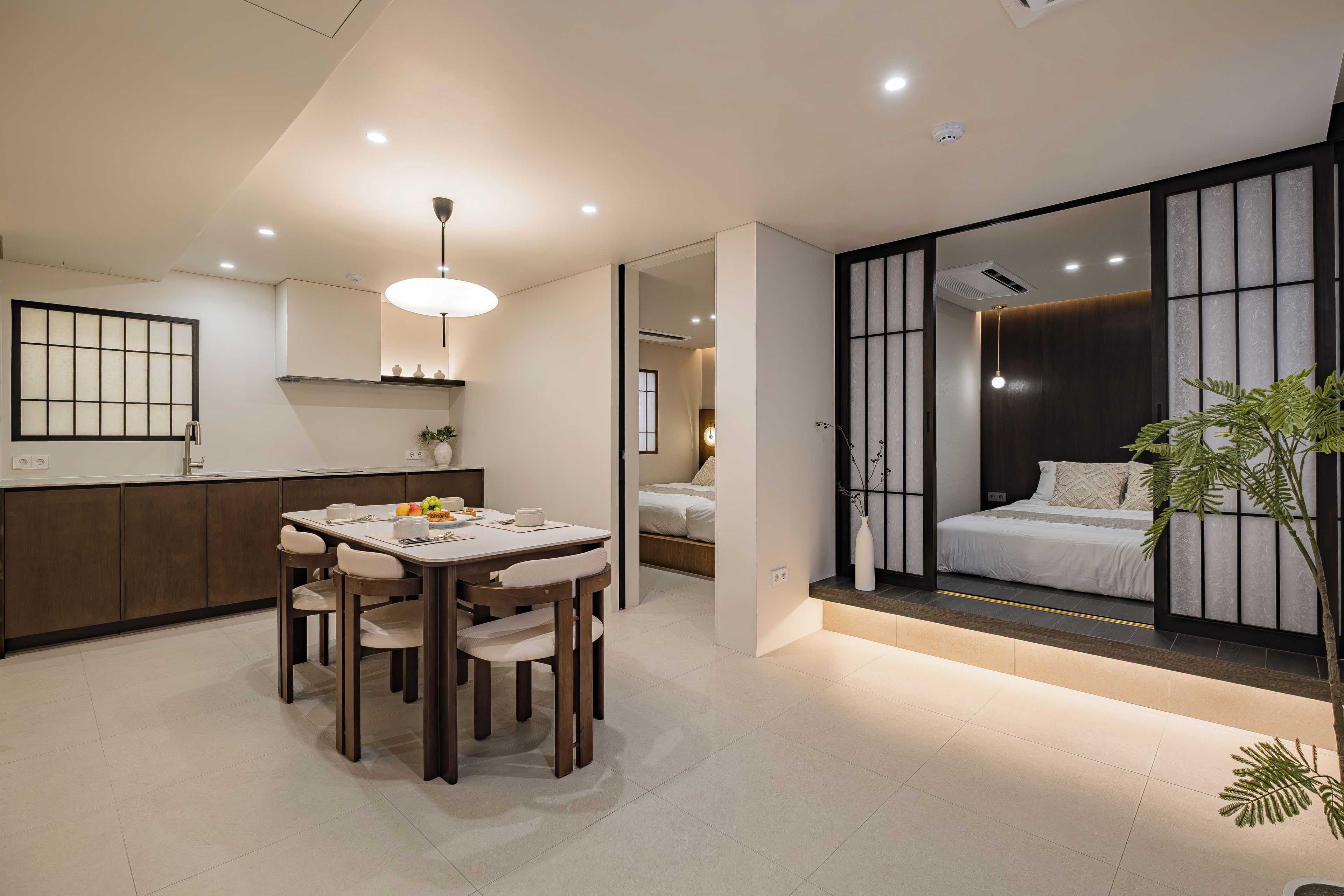 Un interior moderno con comedor, cocina y un dormitorio con ventana grande.