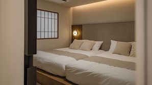 Ein Hotelzimmer mit Bett, Fenster mit Blick und einer Wandleuchte.