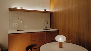 Eine moderne Küche mit einem Holzkasten, einer weißen Arbeitsplatte und einem einzelnen Stuhl.