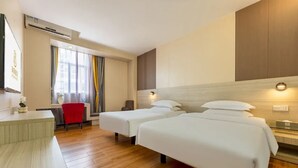 A hotel room with two beds, a desk, a chair, and a window with curtains. - Ruijing Hotel (Dongguan)