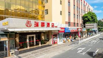 Un hotel con fachada moderna, varios pisos y diferentes letreros.