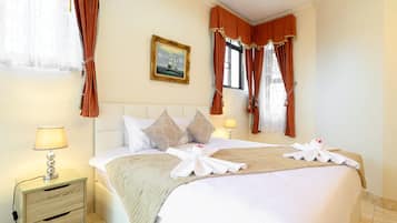 A hotel room with a bed, two bedside tables, a painting on the wall, and curtains.
