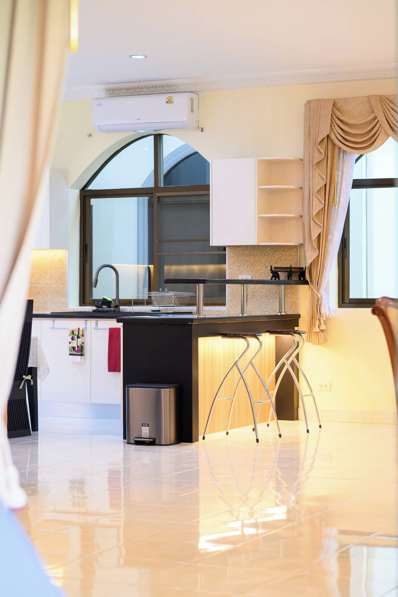 A modern kitchen with a built-in stove, a sink, and a stainless steel trash bin.