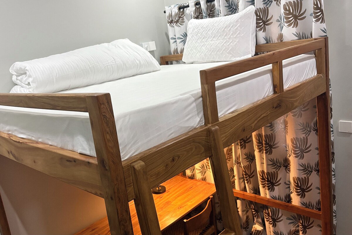 A bunk bed with white bedding and a wooden frame.