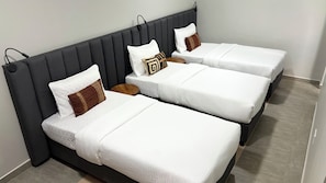 A hotel room with three single beds, each with white bedding and decorative pillows. - Siku Lodge (Arusha)