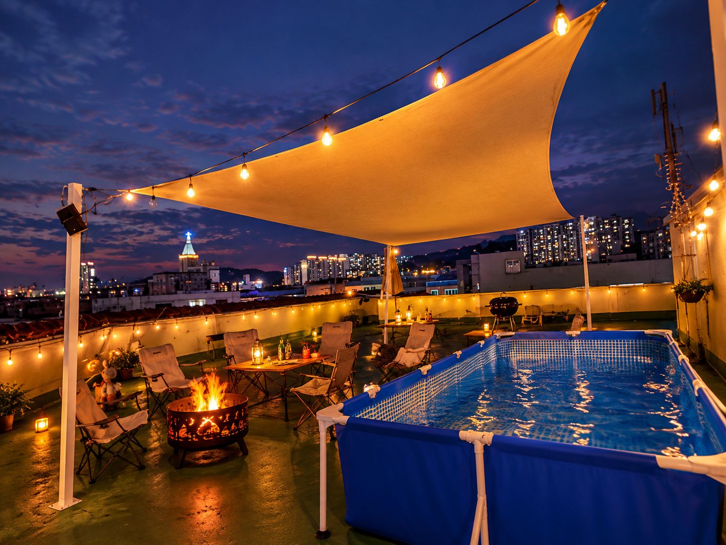 A rooftop pool area with a view of the city skyline at dusk.