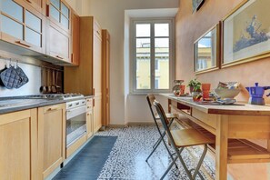 Una cucina compatta con mobili in legno, piano cottura a gas, lavello e finestra che permette l'illuminazione naturale.