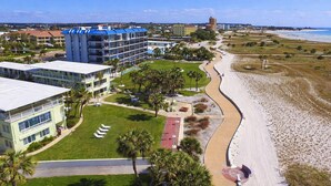 A coastal hotel with multiple buildings, a beach, and a clear sky. - Tropic Terrace (Treasure Island)