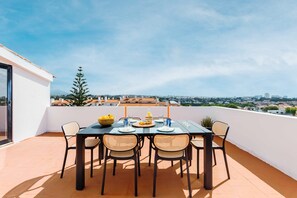 A rooftop terrace with a table set for two, overlooking a cityscape. - Duplex with Private Terrace and A/C in Cascais (Cascais)