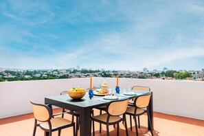 A table set outdoors with a city view, including buildings and greenery. - Duplex with Private Terrace and A/C in Cascais (Cascais)