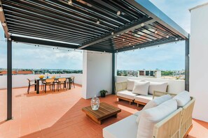 A rooftop terrace with a covered seating area, a dining table, and a sofa. - Duplex with Private Terrace and A/C in Cascais (Cascais)