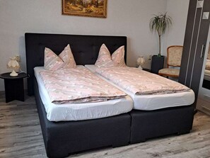 Ein Doppelbett mit dunklem Kopfteil und zwei Nachttischen, jeweils mit einer Lampe.