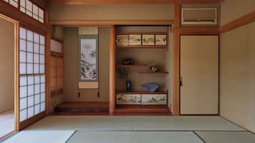 Una habitación japonesa tradicional con suelo de tatami, puertas correderas y un biombó de papel.