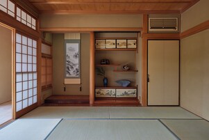 Una habitación japonesa tradicional con suelo de tatami, puertas correderas y un biombó de papel.