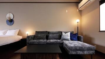 Una sala de estar moderna con un sofá modular, una mesa de centro y dos lámparas de pie.