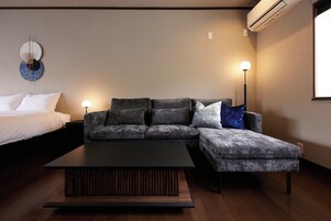 Una sala de estar moderna con un sofá modular, una mesa de centro y dos lámparas de pie.