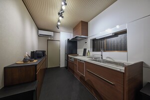 Cocina compacta con horno integrado, un lavamanos y una ventana sobre la encimera.