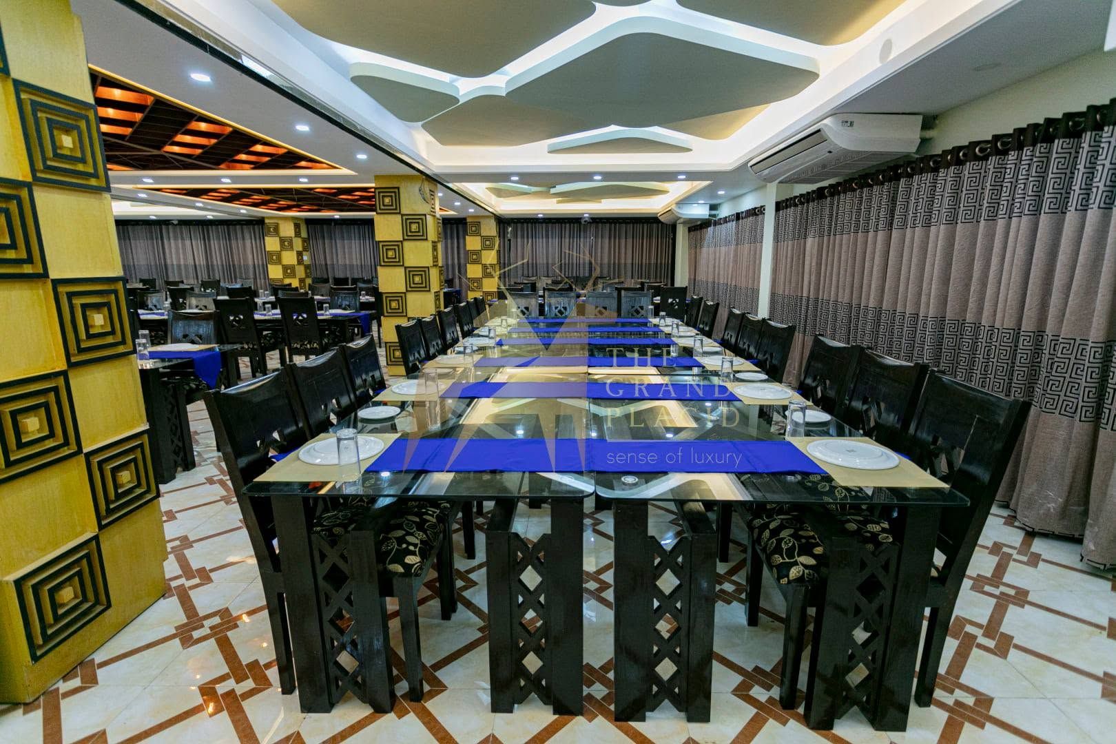 A spacious dining area with a long table set for a meal, surrounded by chairs.