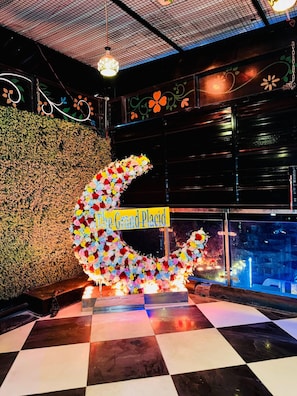 A decorative crescent made of flowers with a sign reading 'The Grand Place.'