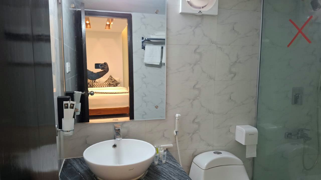 A bathroom with a white sink, a mirror, a towel rack, and a toilet.