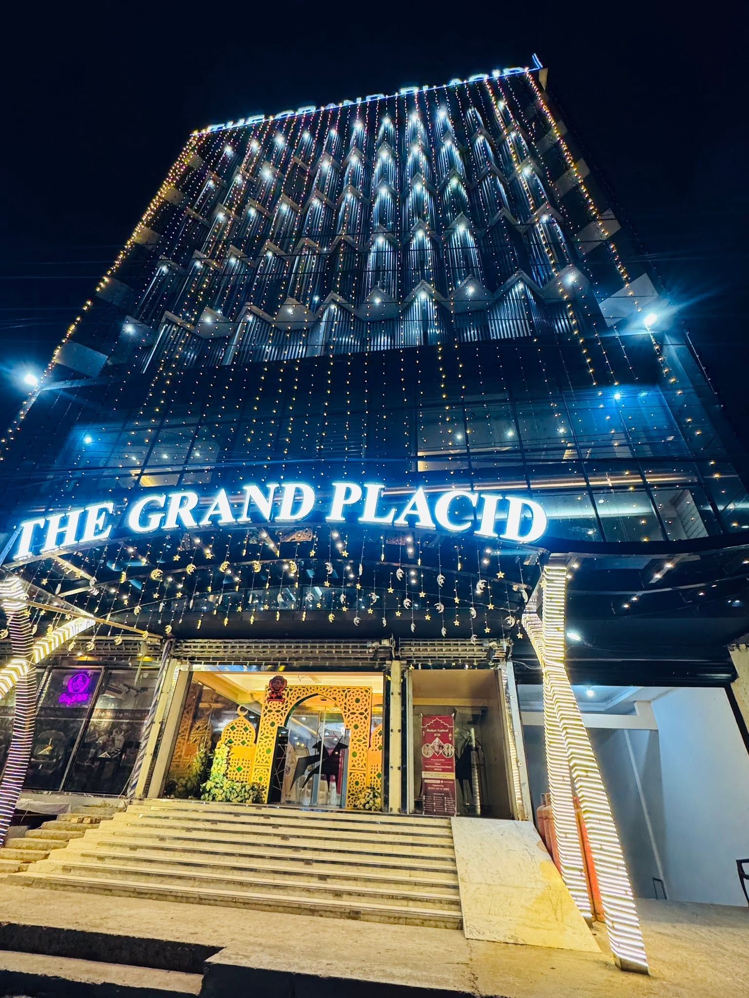 Um edifício com uma placa indicando 'THE GRAND PLACE' e uma escadaria que leva à entrada.