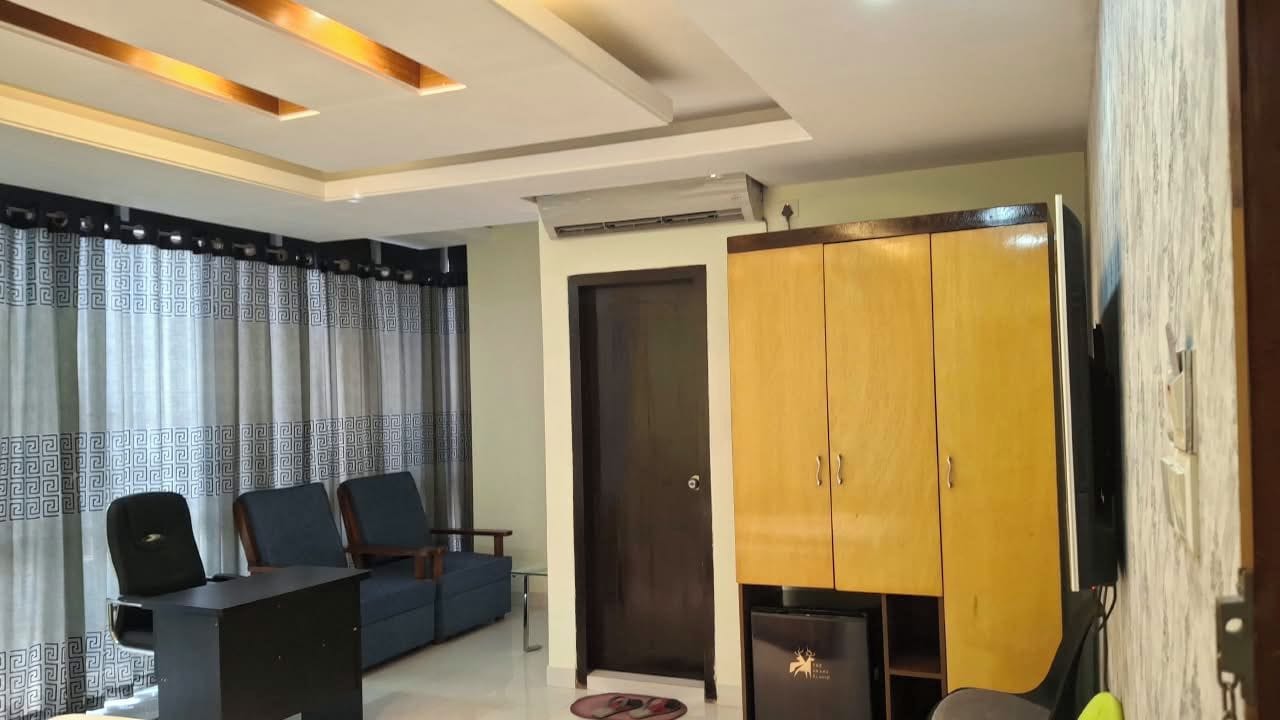 A modern living room with a sofa, chairs, a coffee table, and a wardrobe.