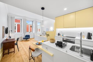 Eine moderne Wohnung mit Küche, Essbereich und Wohnraum mit großen Fenstern.