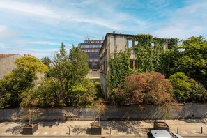 A building with a modern facade, surrounded by lush greenery and flowering plants. - Bright Apartment | Trindade & City Centre (Porto)
