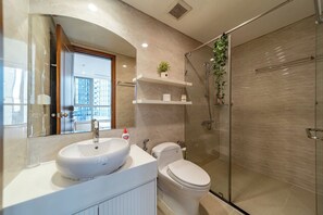 Ein modernes Badezimmer mit einem großen Waschbecken, Toilette und einer Duschkabine aus Glas.