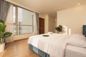 Ein Hotelzimmer mit großem Fenster, einem Bett mit weißen Leinen, einer Topfpflanze und Blick auf Gebäude.