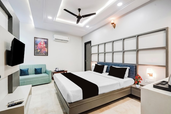 A modern bedroom with a bed, a sofa, a TV, and an air conditioning unit.