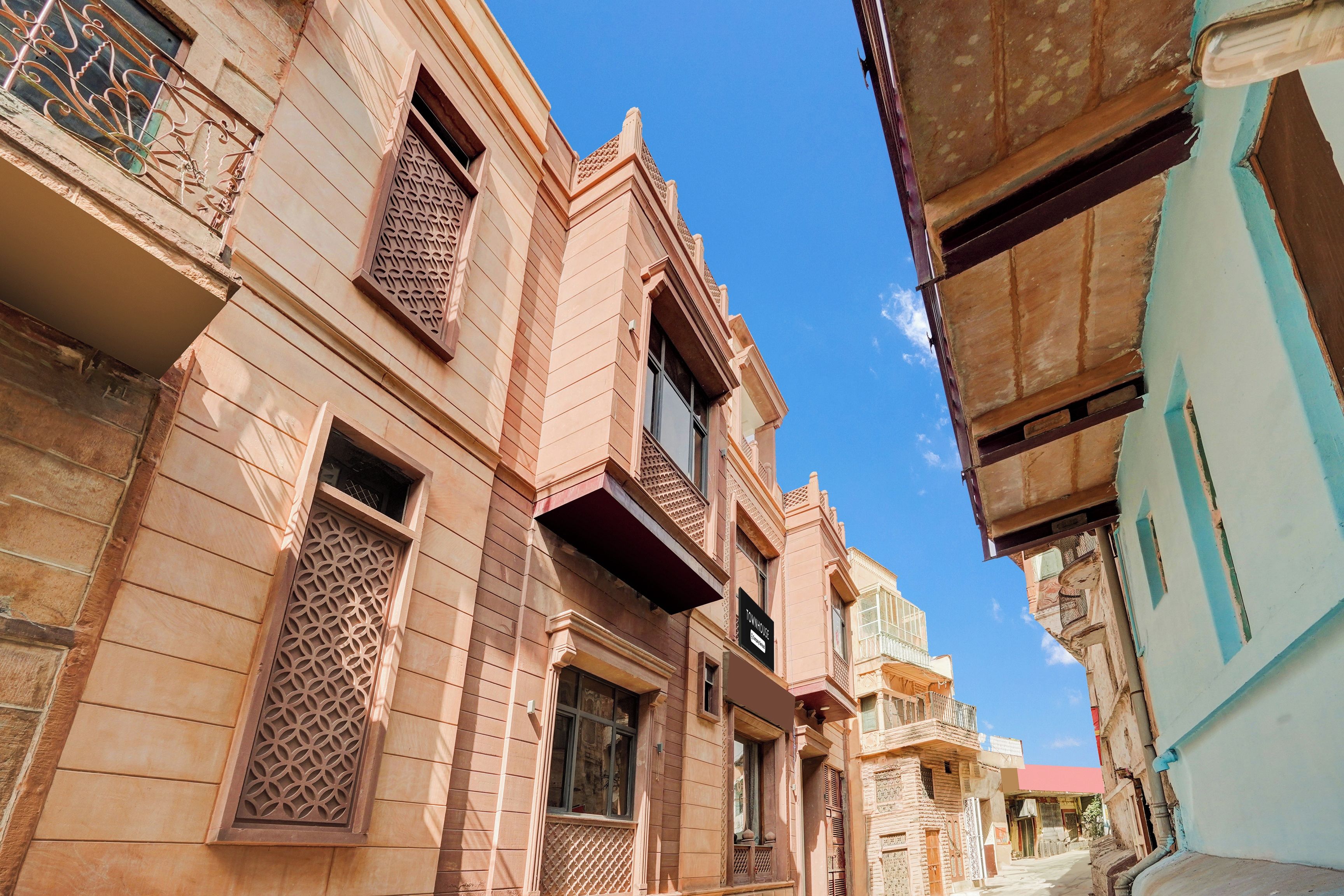 Una calle estrecha con arquitectura tradicional, que incluye balcones ornamentados y celosías.