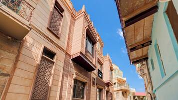 Una calle estrecha con arquitectura tradicional, que incluye balcones ornamentados y celosías.