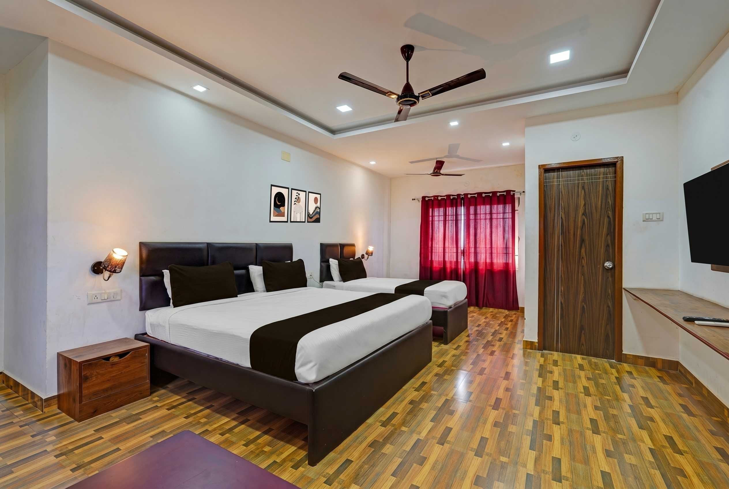 Un dormitorio moderno con una cama grande, un ventilador de techo y piso de madera.