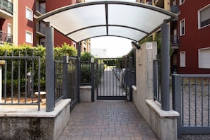 A gated entrance to a residential building with a covered walkway and a number sign indicating the unit number. - A bright 75-square-meter three-room apartment, for up to six guests, located on the first floor of a building (equipped with an elevator, though not suitable for people with disabilities).It enjoys a strategic location near Veronafiere and offers excelle (Verona)