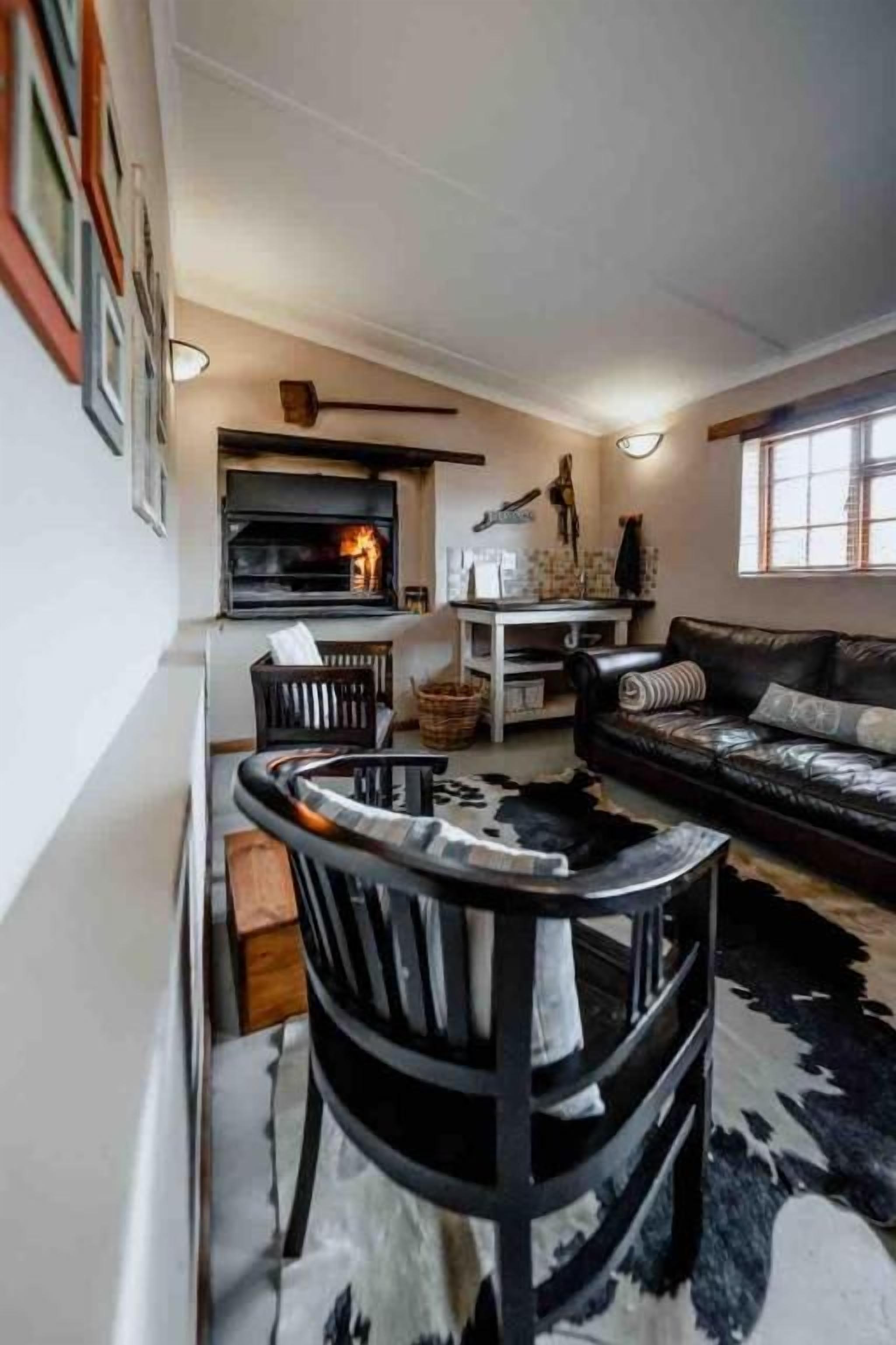 Un salon avec une cheminée, un canapé, une table basse et un tapis à motifs.