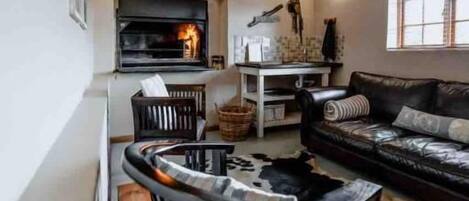 A living room with a fireplace, a sofa, a coffee table, and a patterned rug.