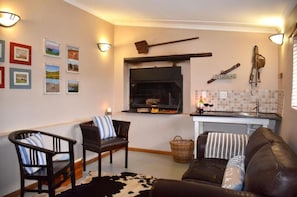 Una sala de estar acogedora con chimenea, un comedor con pileta y una pared decorada con fotografías enmarcadas.