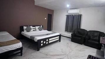 Una habitación de hotel con una cama, un sofá, una mesita de café y un ventilador de techo.