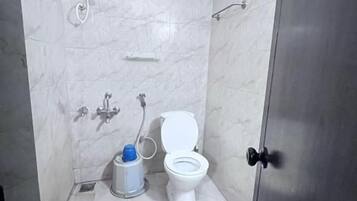 Un baño con inodoro, ducha y lavabo.
