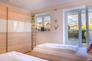 A bedroom with a bed, a window, and a view of the outside. - Holiday apartment with 2 bedrooms (Garmisch-Partenkirchen)