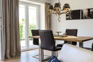 A dining area with a table, chairs, and a chandelier. - Holiday apartment with 2 bedrooms (Garmisch-Partenkirchen)