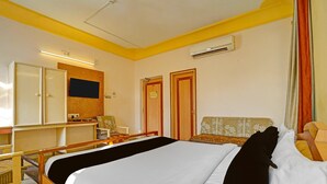 Una habitación de hotel con una cama, un escritorio, una silla y un armario.