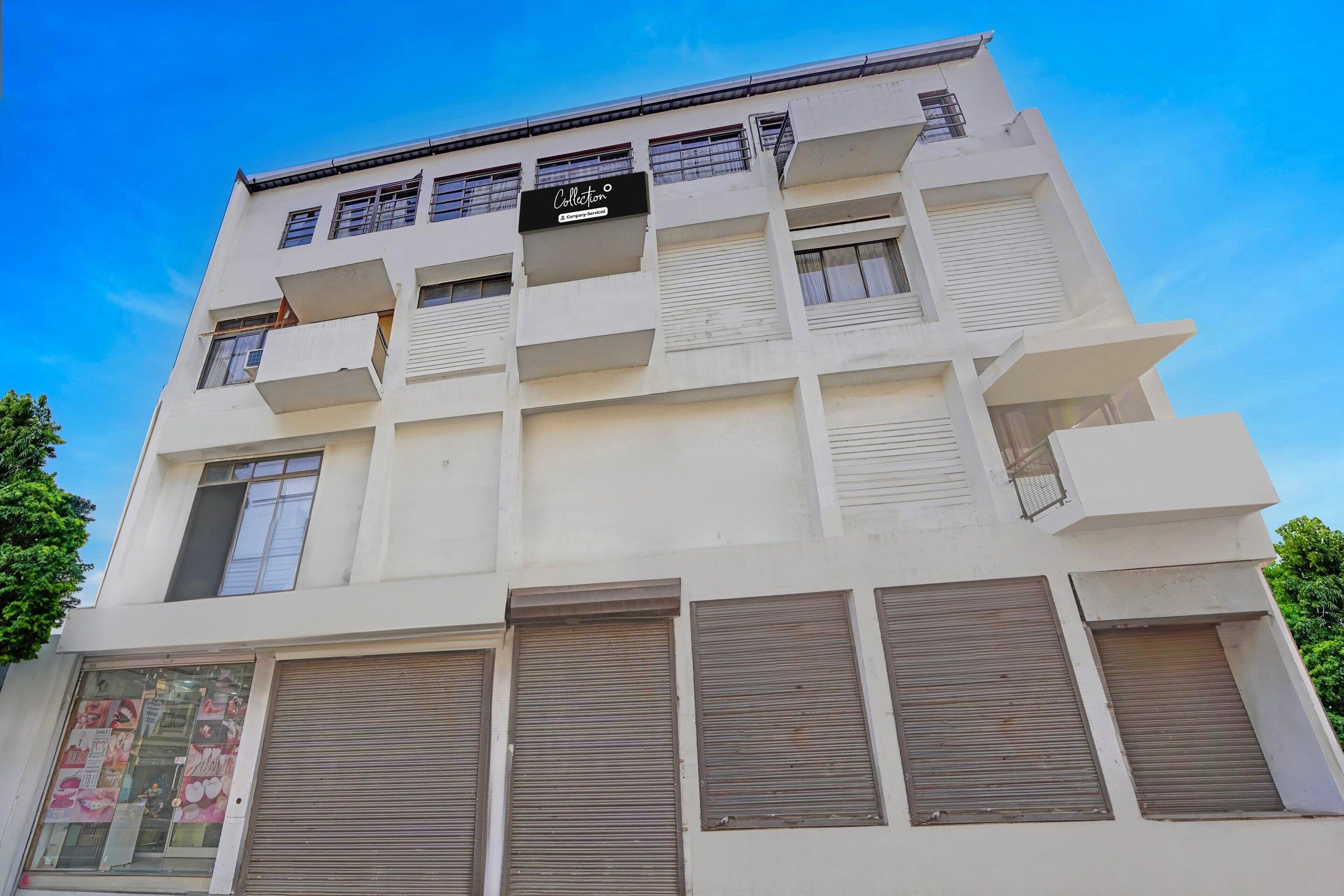 A multi-story building with a sign indicating it is a company-serviced collection.